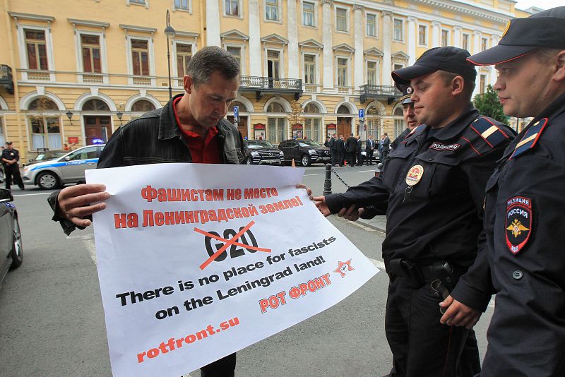 Un policía ruso habla con un activista contrario a la reunión del G20