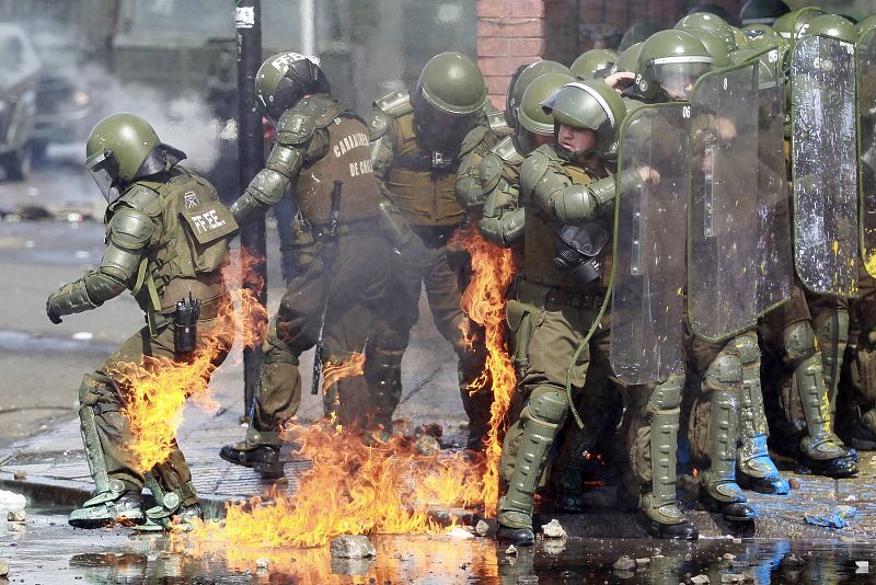 Las llamas provocadas por cócteles molotov alcanzan a varios antidisturbios durante los disturbios ocurridos tras la manifestación en memoria de los desaparecidos por el golpe de Estado de Chile, que acabó con la vida del presidente Salvador Allende