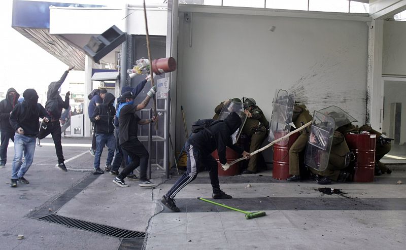 Varios manifestantes lanzan objetos a los antidisturbios durante los disturbios ocurridos en Chile tras la marcha en conmemoración del golpe de Estado de Pinochet que acabó con el Gobierno y la vida de Salvador Allende el 11 de septiembre de 1973