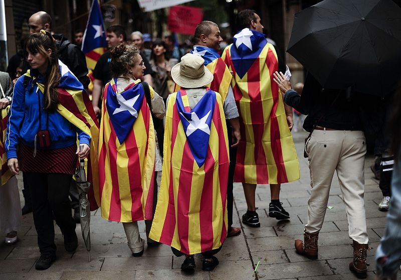 Un grupo de personas camina por Barcelona con la bandera estelada a favor de la independencia de Cataluña.