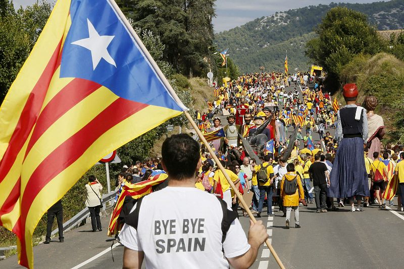 Un hombre porta una bandera independentista ('estelada') junto a un grupo de personas que participa, a su paso entre las poblaciones de Avinyonet del Penedès y Cantallops, en la "Vía Catalana hacia la Independencia".