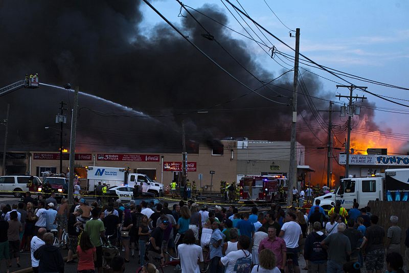 Decenas de ciudadanos han acudido a observar cómo los bomberos trataban de sofocar el fuego que ha arrasado varios bloques en la zona costera de Nueva Jersey, Estados Unidos