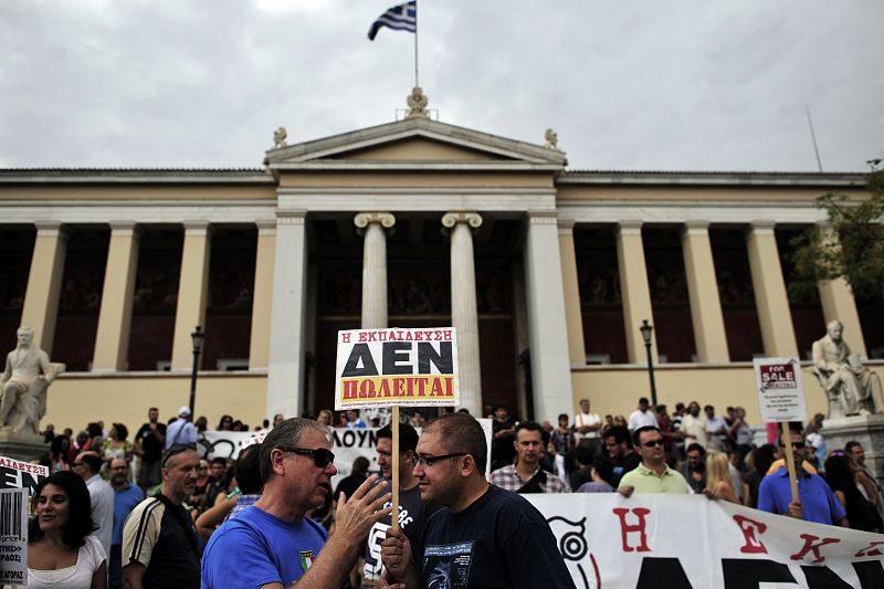 Profesores griegos se manifiestan delante de la Universidad de Atenas con una pancarta que dice "La educación no está en venta"