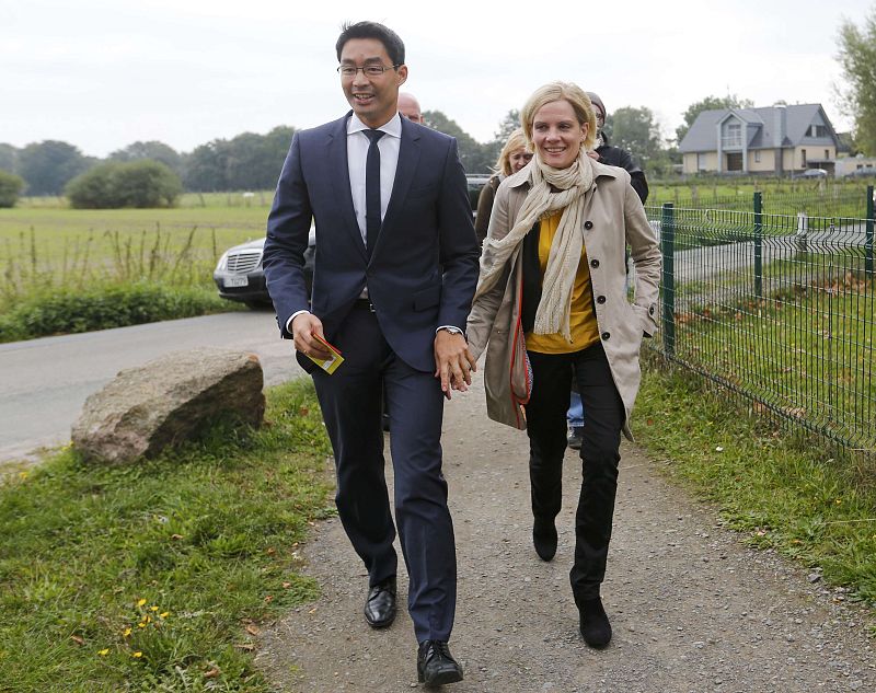 Roesler, German Economy Minister and chairman of the Free Democrats (FDP) and his wife Wiebke make their way to a polling station to cast their votes in the German general election (Bundestagswahl) in Isernhagen
