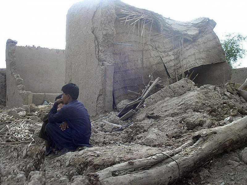 Varias personas permanecen junto a sus casas en ruinas