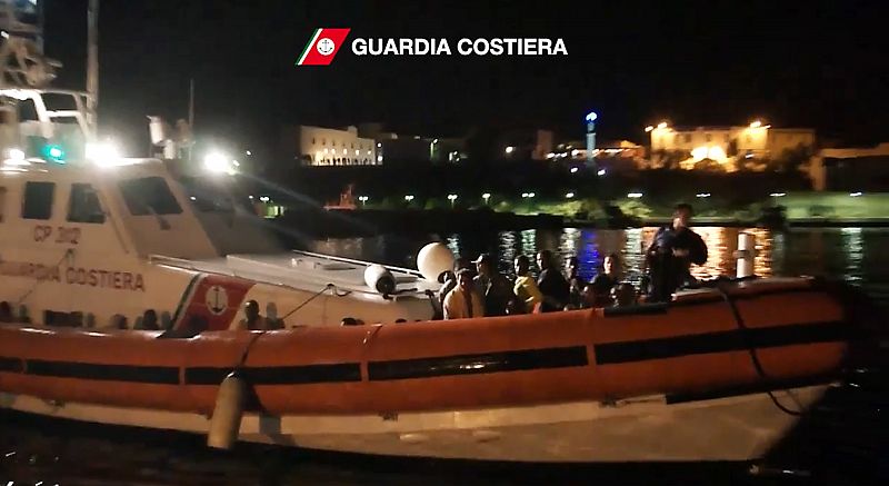 Fotografía tomada de un vídeo de la Guardia Costera italiana muestra uno de sus barcos llegando a puerto con rescatados