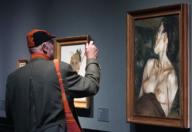 Visitor takes photographs of paintings by British painter Freud during a preview of an exhibition at Kunsthistorisches Museum in Vienna