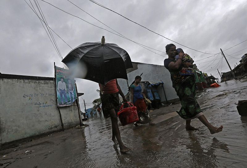 A woman carries her baby as she moves to a safer place with others at the village Donkuru