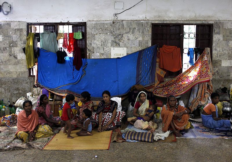 People take shelter at a wedding hall after leaving their houses to take shelter from the impact of the approaching Cyclone Phailin, in the eastern Indian state of Odisha