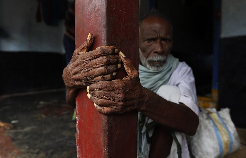 A man sits outside his house as he waits to be evacuated to a safer place at Donkuru village