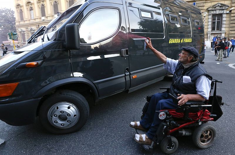 Un manifestante lanza sprays contra la Policía durante las protestas contra las medidas de austeridad en Roma