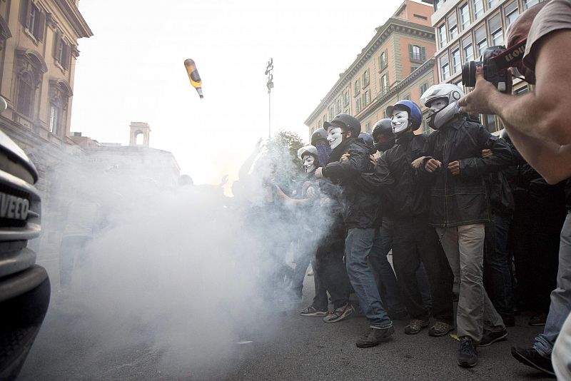 Los manifestantes con máscaras de Guy Fawkes se enfrentan a la Policía durante las protestas contra las medidas de austeridad en Roma