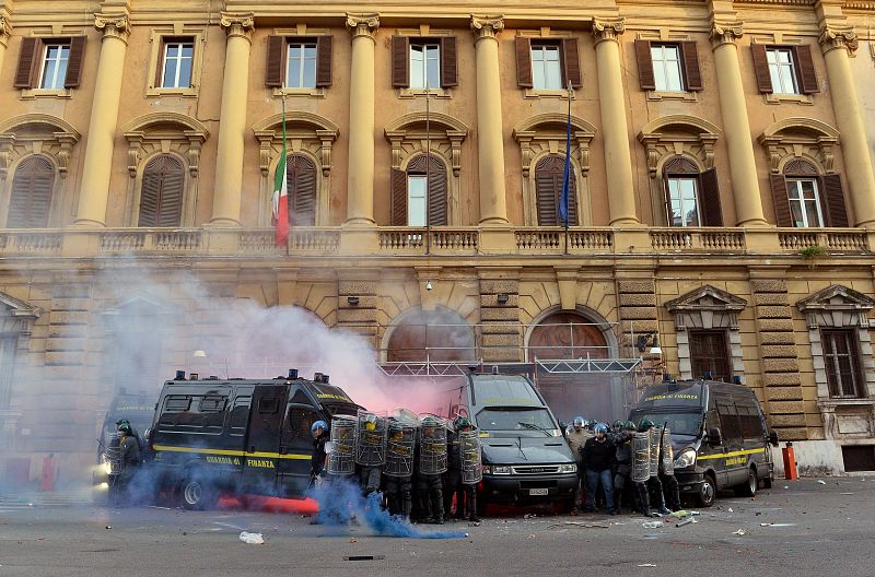 Las fuerzas de seguridad se protegen durante los disturbios producidos frente al Ministerio de Economía en Roma