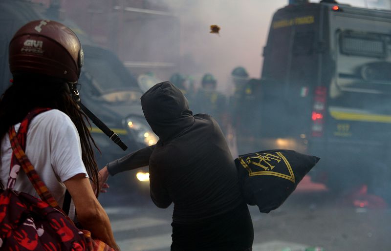 Uno de los ciudadanos lanza objetos contra la Policía en las protestas contra la austeridad ante el ministerio de Finanzas, en Roma