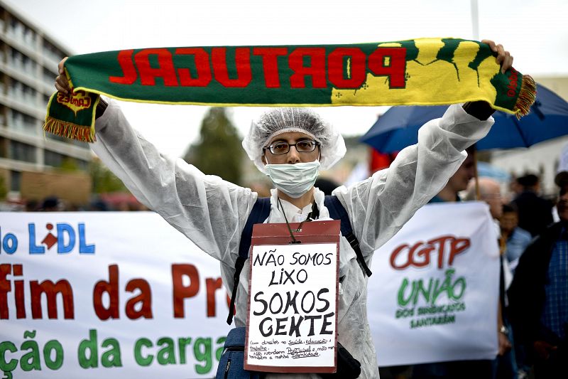 Un manifestante muestra un cartel en el que se lee, en portugués "No somos basura, somos personas", durante las protestas contra los recortes anunciados por el Gobierno luso