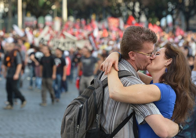 Una pareja se besa durante las protestas contra los recortes y la austeridad en Roma, donde se han concentrado decenas de miles de personas