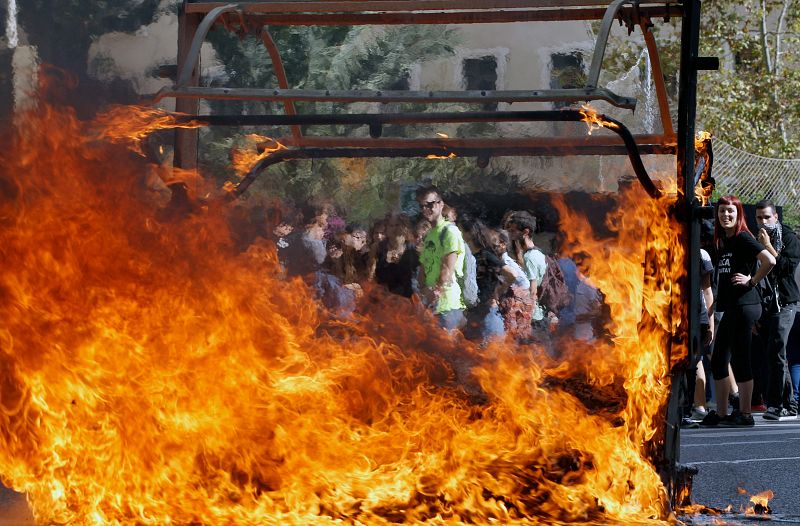 Un contenedor incendiado al término de la protesta en el centro de la capital valenciana.