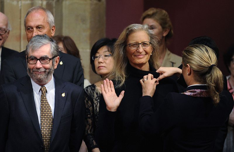 U.S. photographer Leibovitz waves as a hostess pins a badge on her during a reception for the Prince of Asturias Awards winners in Oviedo
