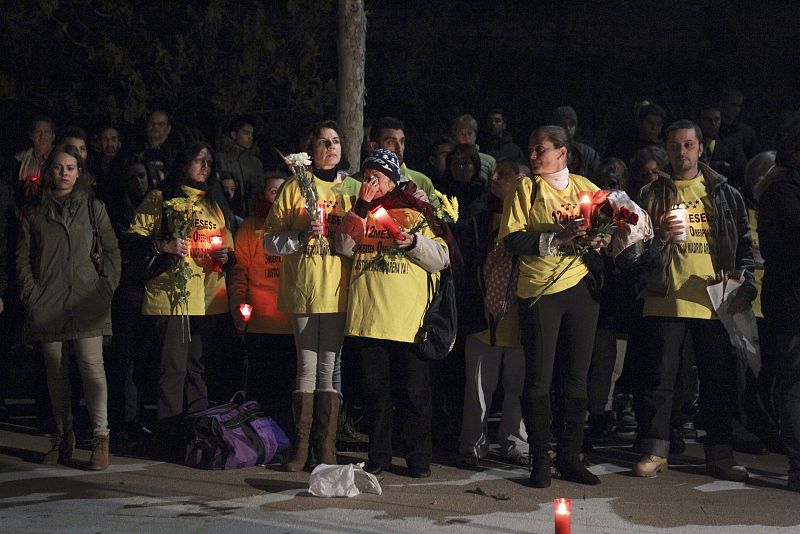 Familiares, amigos y conocidos de las cinco jóvenes muertas en la tragedia del Madrid Arena hace un año, rezan durante la vigilia que se celebra hoy junto al pabellón para recordar a las víctimas.