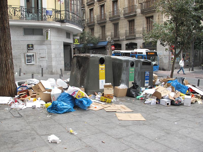 Basura acumulada en la Plaza Carlos Cambronero, donde uno de los contenedores está quemado