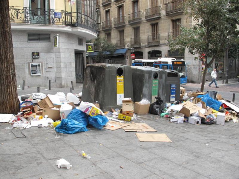Basura acumulada en la Plaza Carlos Cambronero, donde uno de los contenedores está quemado