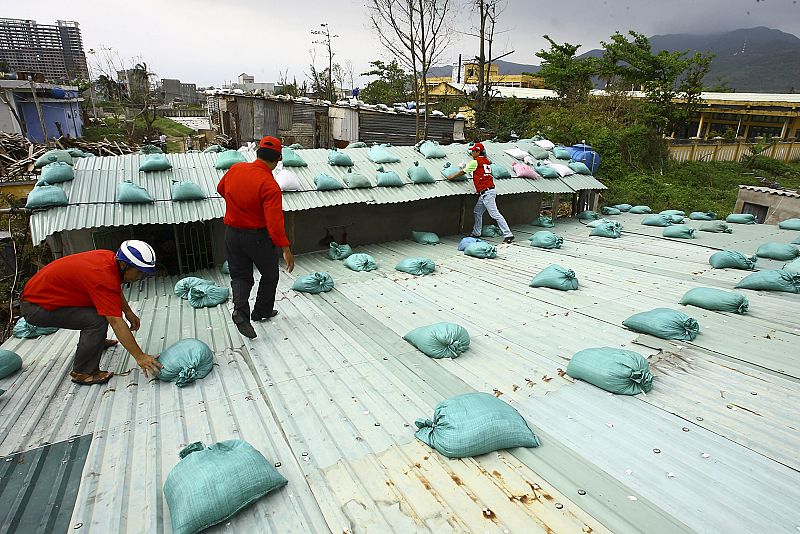 Red Cross volunteers and staff place sandbags on houses in Da Nang