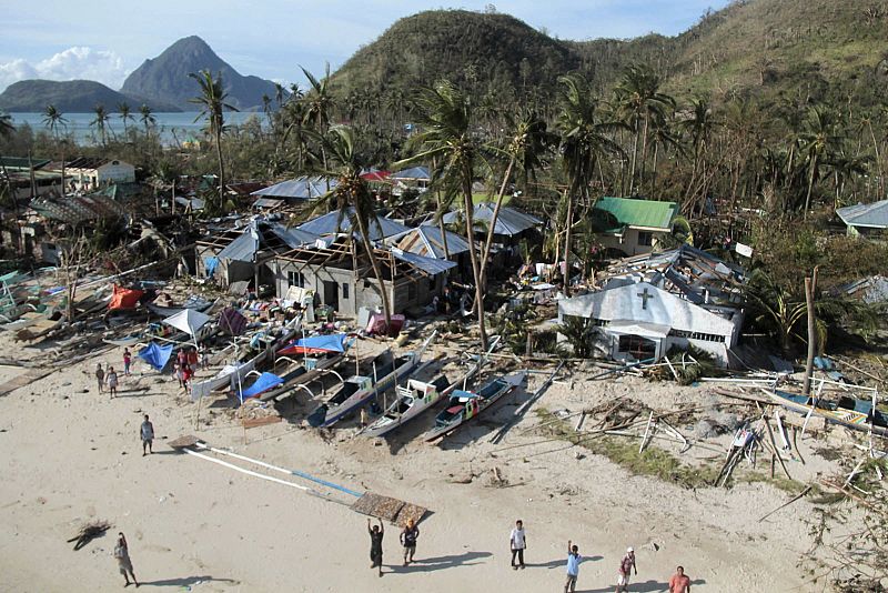 An aerial view shows damaged houses, as residents wave for help after Typhoon Haiyan hit a village in Panay island