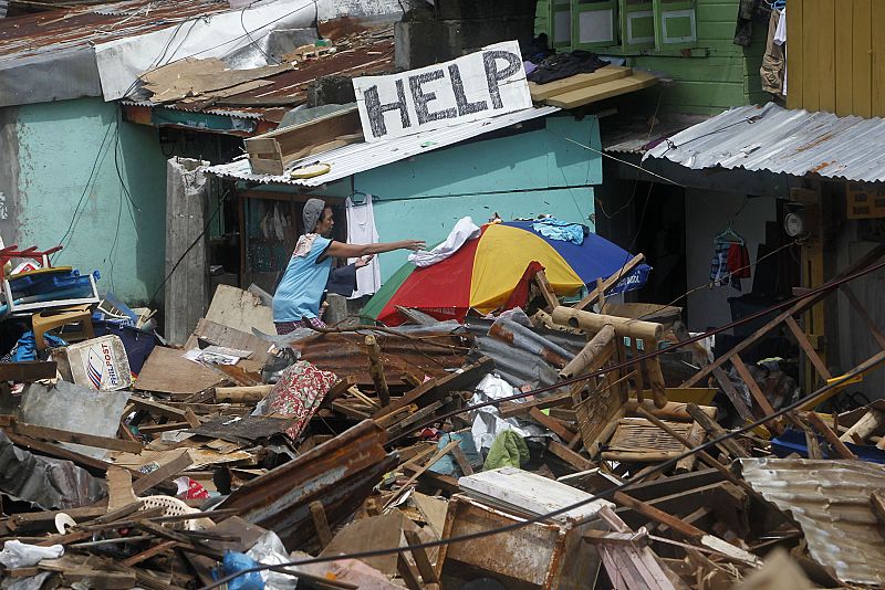 Un cartel con la palabra "Ayuda" entre los restos destrozados de viviendas en Tacloban, capital de la isla de Leyte, la zona más afectada por el tifón Haiyan