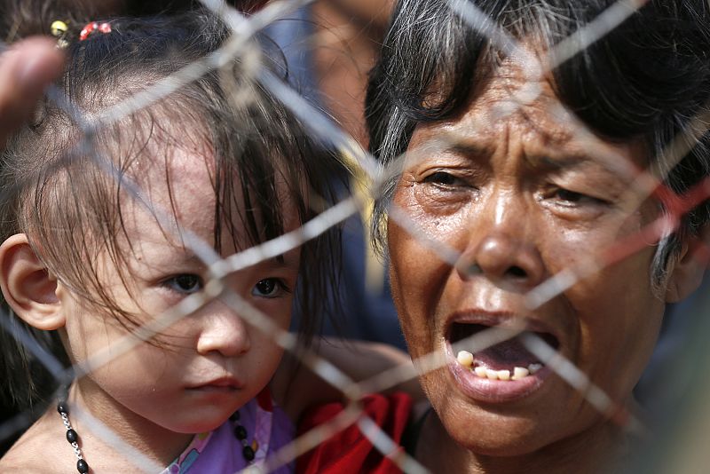 Seis días después de que el tifón Haiyan o Yolanda golpeara Filipinas, la ayuda se distribuye lentamente. Una mujer y su nieta esperan ser evacuadas de Tacloban, isla de Leyte