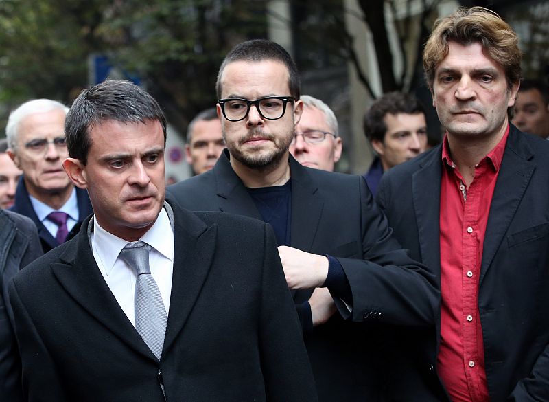 El ministro de Interior francés, Manuel Valls, junto al presidente del diario Libération, Nicolas Demorand, y el director, Fabrice Rousselot.