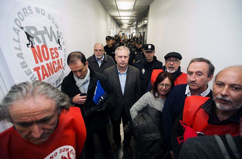 Miembros de la Policía Nacional y el Comisario Jefe de la policía Autonómica, Álvaro Rodríguez (c) ,entra a las instalaciones para desalojar a sus trabajadores.