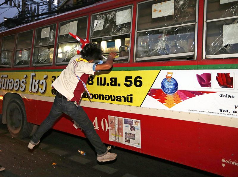Un manifestante antigubernamental ataca el autobús que transporta a "camisas rojas" a la concentración progubernamental