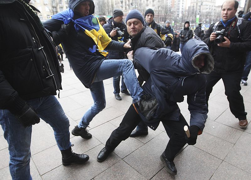 Participants of the rally attack an unidentified man, treated as a provocateur by the rally organizers, in front of the Kiev City State Administration (Kiev City Council) building during a rally held by supporters of EU integration in Kiev