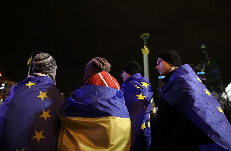 Protesters wrapped in EU and Ukrainian flags attend a demonstration at Independence Square in Kiev