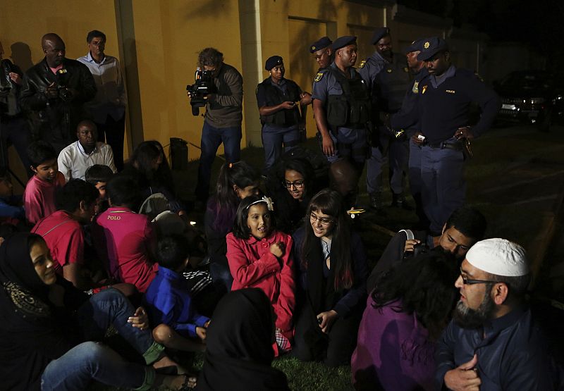 Un grupo de ciudadanos se concentra para cantar y rezar en memoria del fallecido expresidente de Sudáfrica, Nelson Mandela, frente a su casa en Houghton.