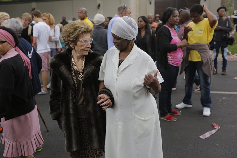 Varias personas muestran su respeto al expresidente sudafricano Nelson Mandela frente a su última residencia