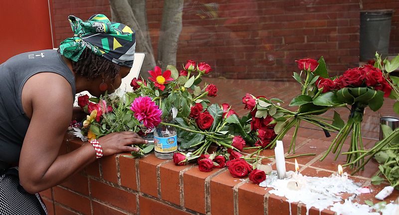 Una mujer deposita flores en Soweto por el fallecimiento de Mandela