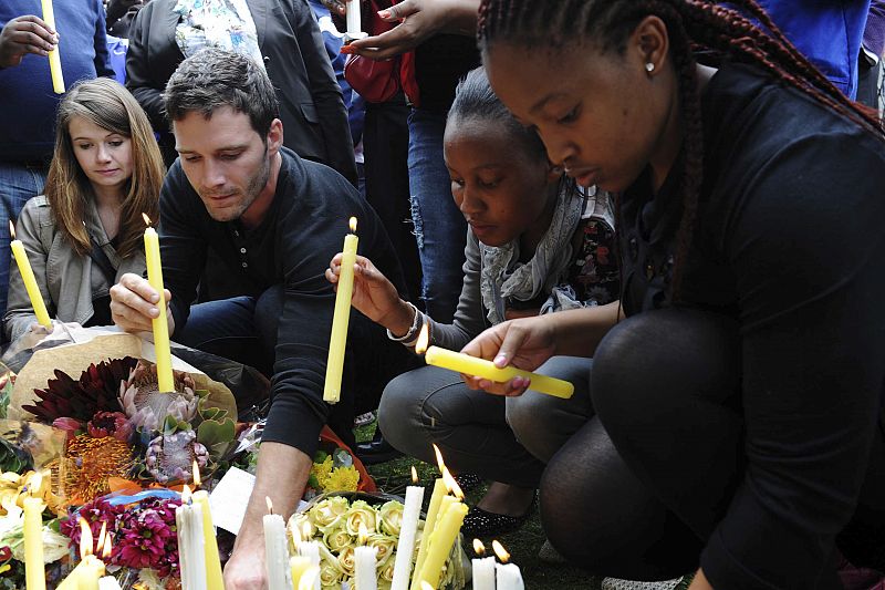 Varios ciudadanos depositan velas y flores en Johannesburgo a las afueras de la última residencia de Nelson Mandela