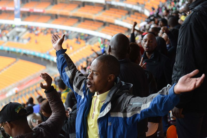 Horas antes del comienzo del servicio religioso, los sudafricanos cantaban y celebraban en las gradas del Soccer City.