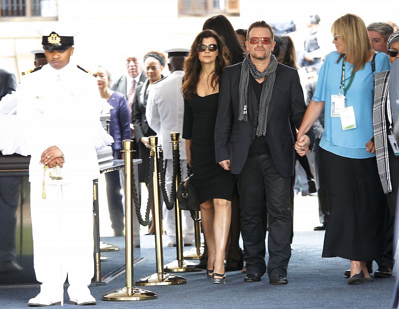 El cantante Bono, escoltado por su esposa y Zelda la Grange, exasistente de Mandela.