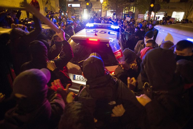 Varios manifestantes rodean y golpean coches policiales tras la concentración "Rodea el Congreso"