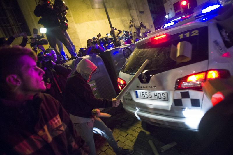 Un manifestante golpea la luna trasera de un coche policial durante los disturbios ocurridos en Madrid tras la movilización "Rodea el Congreso"