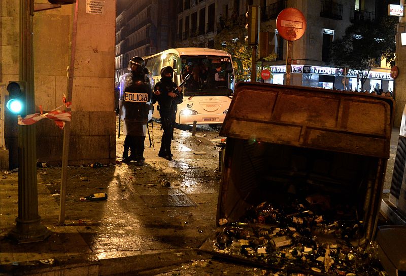 Un contenedor volcado y quemado durante los disturbios provocados tras la movilización "Rodea el Congreso" en Madrid