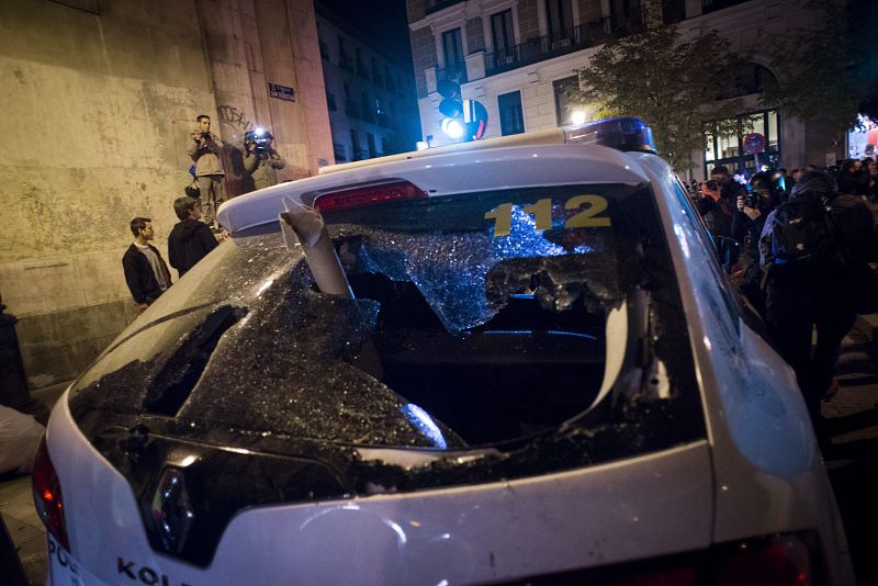 Un coche de policía con la luna trasera rota durante los incidentes registrados tras la concentración "Rodea el Congreso" que se ha desarrollado en las inmediaciones de la Cámara Baja en Madrid