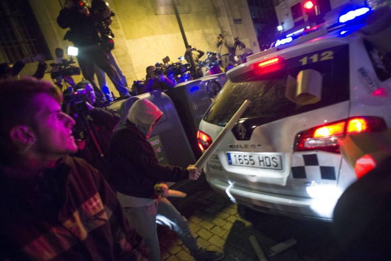Un manifestante golpea la luna trasera de un coche policial durante los disturbios ocurridos en Madrid tras la movilización "Rodea el Congreso"