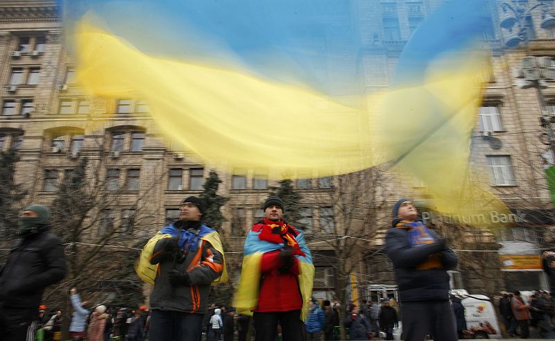 Pro-European integration protesters wave an Ukrainian national flag as they gather for a mass rally at Independence Square in Kiev