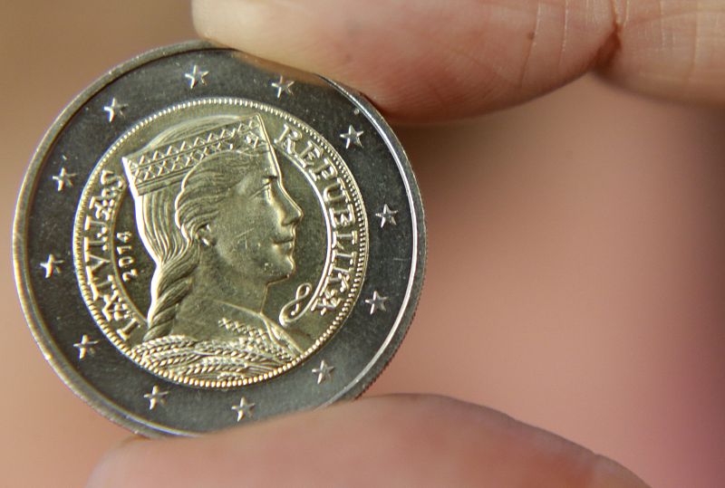A woman holds a Latvia's two euro coin during presentation in Riga