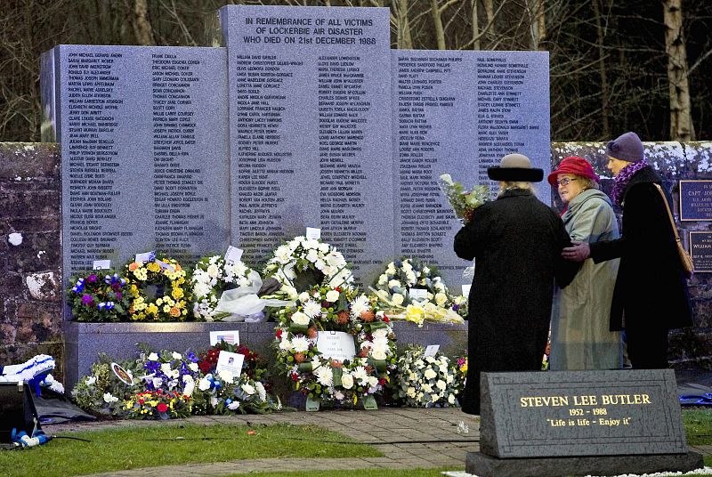 Varias personas depositan flores en memoria de las 270 víctimas.