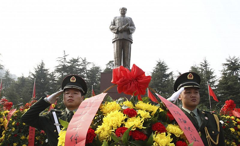 Dos policías chinos saludan frente a la estatua del fundador de la China socialista (1949), Mao Zedong