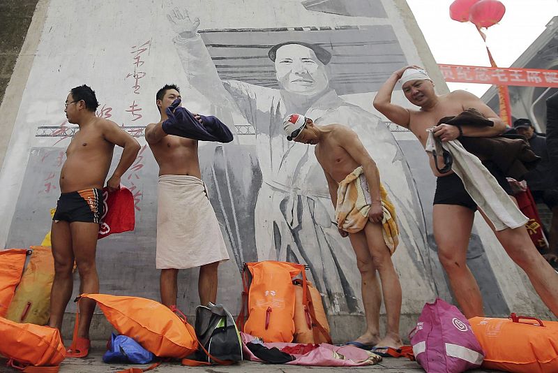 Nadadores se visten junto a una fotografía gigante de Mai Zedong